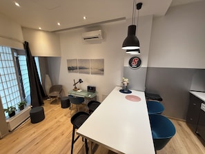 A modern office space with a white desk, black chairs, a glass table, and a hanging pendant light. - Modern studio downtown Budapest, next to airport road, also for business trips (Budapest)
