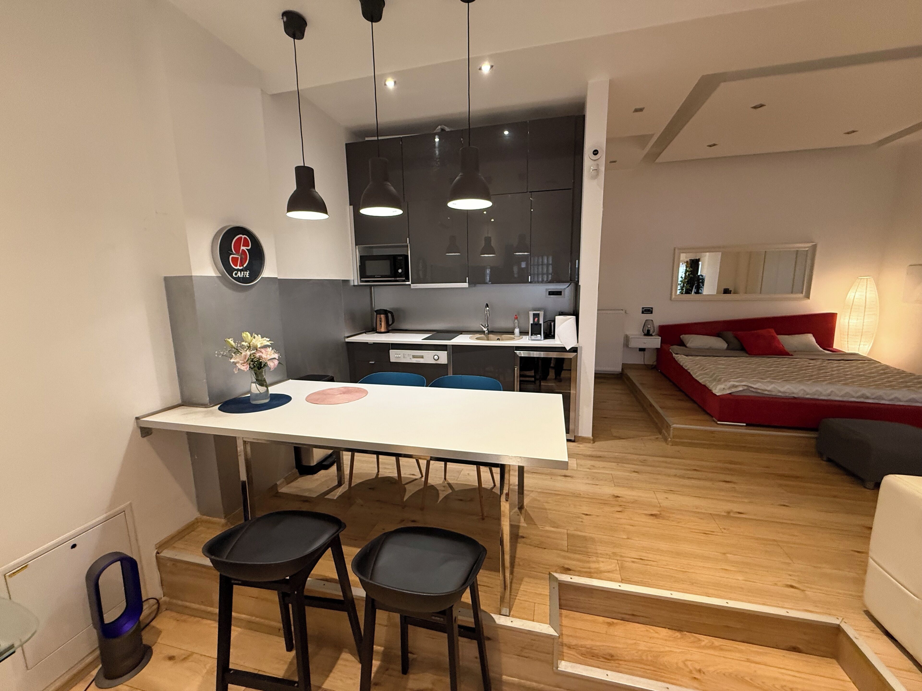 Un appartement moderne comprenant une cuisine, un coin repas et une chambre.