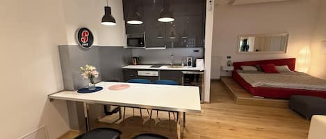 Un appartement moderne comprenant une cuisine, un coin repas et une chambre.
