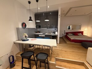 Een modern appartement met keuken, eetgedeelte en slaapkamer.