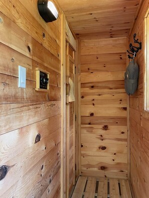 Ein Holzinterieur mit einer Tür, einer Wandleuchte und einer aufhängbaren Tasche.