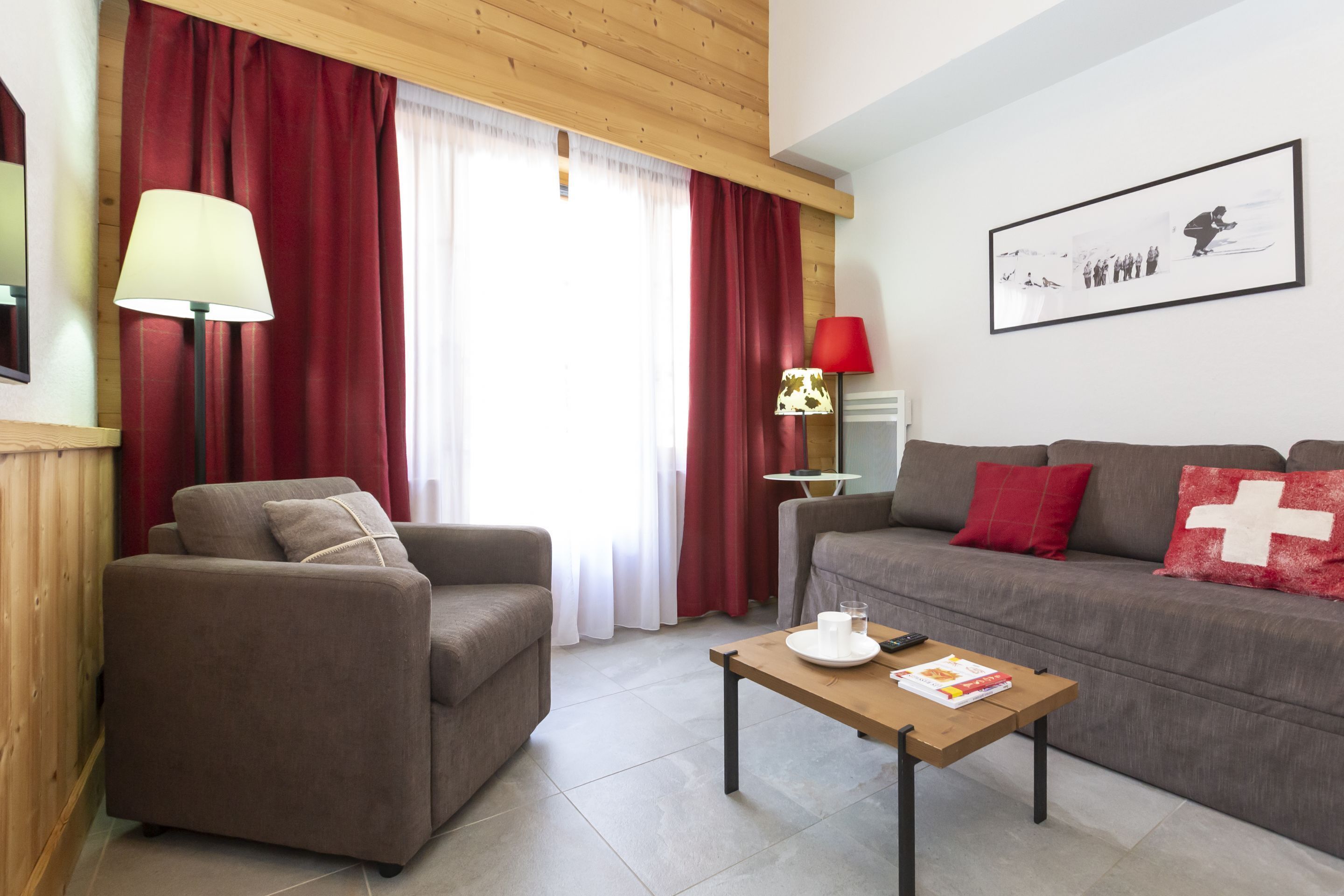 A living room with a sofa, armchair, coffee table, and two lamps.