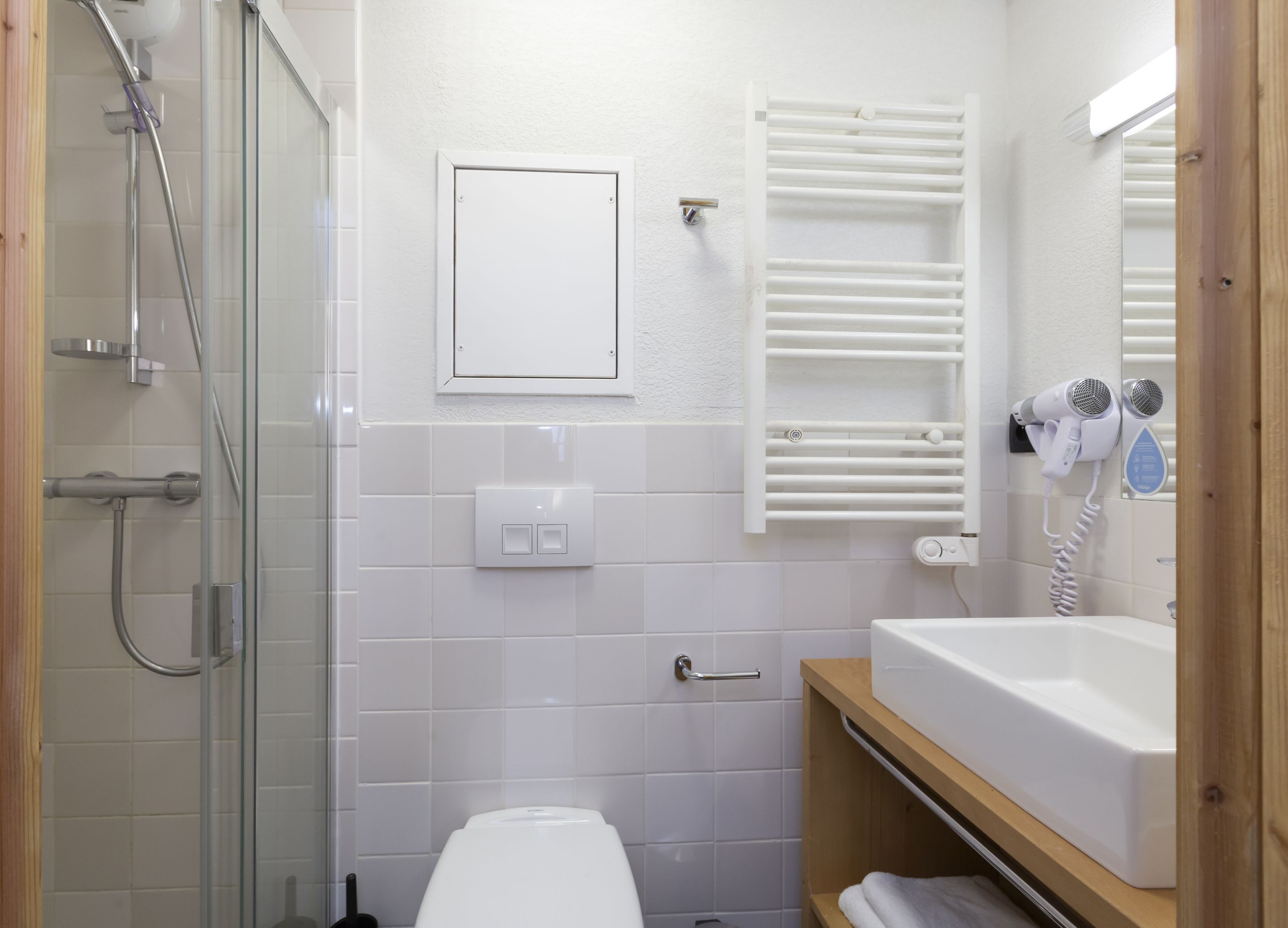 Een badkamer met douche, toilet en wastafel met spiegel.