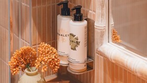 A bathroom with a mirror, a towel rack, and two bottles of hand cream on a shelf. - The Muddy Fox (Solihull)