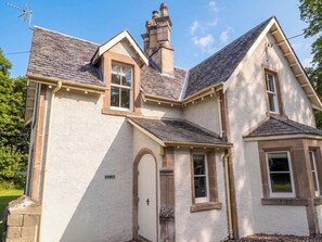 A two-story house with a stone facade, a chimney, and a door labeled 'Station Lodge.'