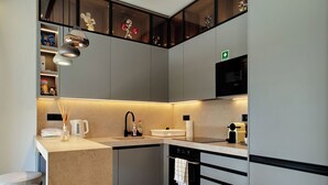A modern kitchen with a built-in microwave, a coffee machine, and a sink. - Designer Flat in Voula Center (Voula)