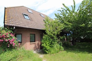 A brick house with a sloped roof, two skylights, and a small front porch. - Close to the beach and centrally located (Wustrow)