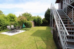 A backyard with a patio, a staircase, and a small shed. - Close to the beach and centrally located (Wustrow)