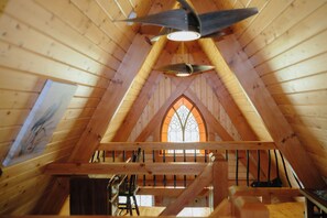 An attic room with wooden beams, a wooden ceiling fan, and a stained glass window. - Riv-A-Frame on the Doe River in Elizabethton, TN (Elizabethton)