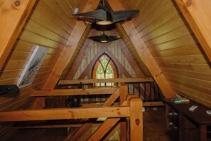 A wooden interior with a sloped ceiling, a stained glass window, and a wooden bench. - Riv-A-Frame on the Doe River in Elizabethton, TN (Elizabethton)