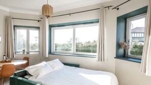 A bedroom with a bed, a desk, a chair, a window, and a view of greenery. - Studio Standard (Saint-Jean-de-Luz)