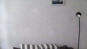 Una sala de estar moderna con un sofá marrón oscuro, cojines a rayas, una mesita redonda y una alfombra mullida.