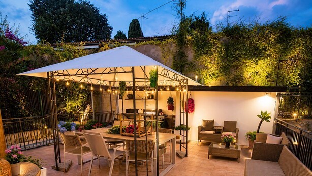 Une terrasse extérieure dotée d’un espace repas couvert, d’un coin salon et d’un petit coin cuisine.