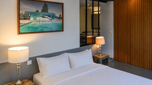 Ein Hotelzimmer mit einem Bett, zwei Nachttischlampen, einem Bild von einem Schwimmbad und einer Wand mit Holzverkleidung.