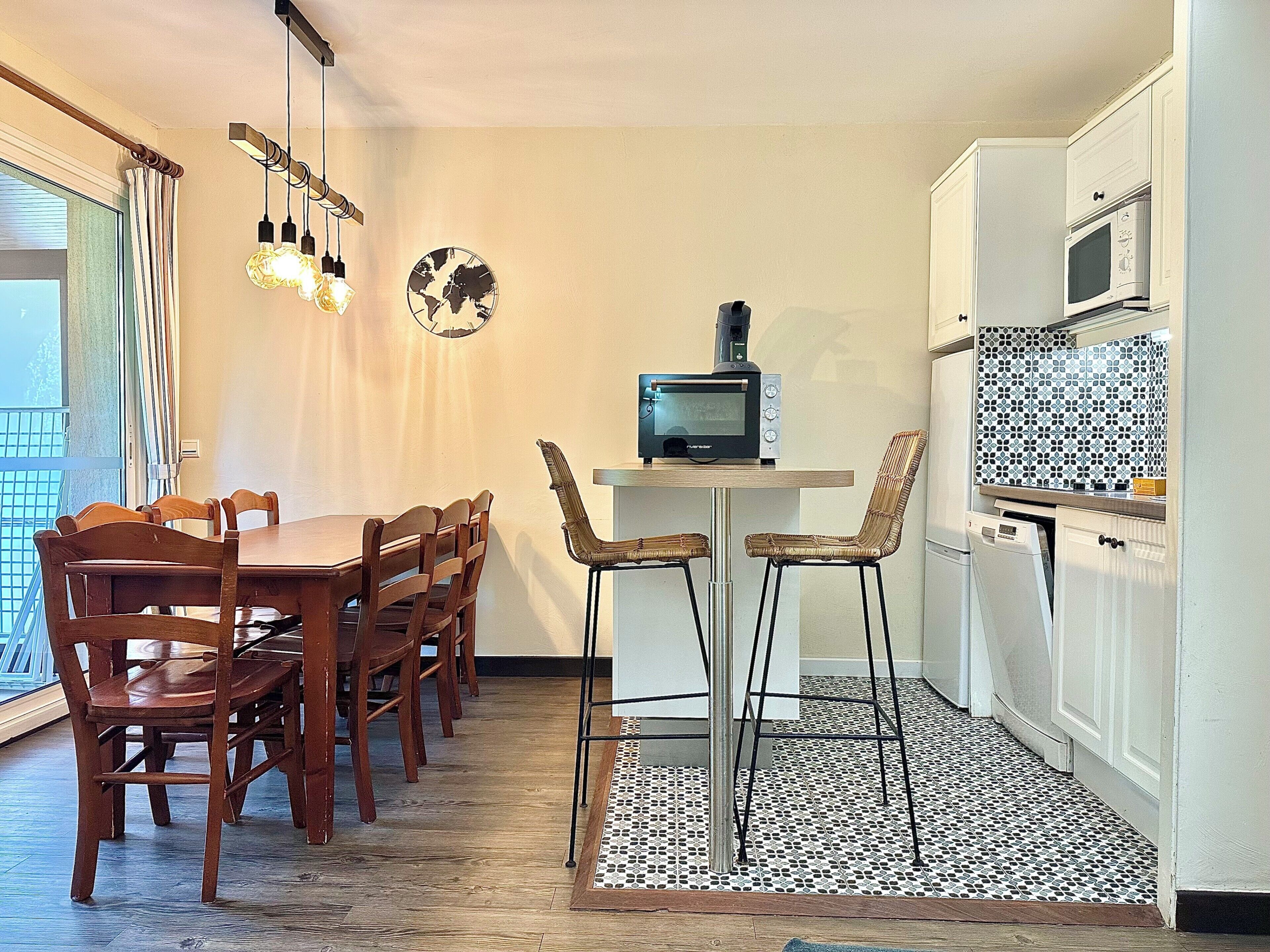 A compact kitchen with a dining area, a small TV, and a microwave.