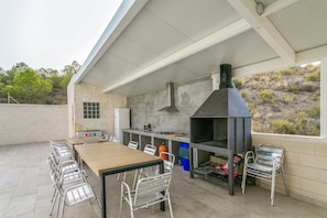 Terrassa exterior amb una barbacoa, seients i vistes al paisatge circumdant.