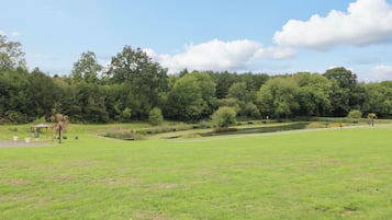 Ein Park mit Teich, Spazierwegen und einem Pavillon.