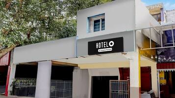 A building with a sign that reads 'HOTEL' and 'Company-Serviced.' There are two visible entrances with metal gates.