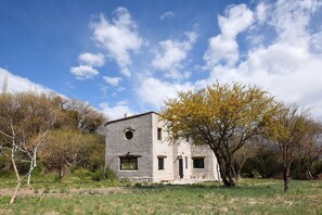 Un edificio rústico con fachada de piedra, techo plano y una ventana pequeña.