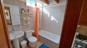 Um banheiro com pia, vaso sanitário e banheira.
