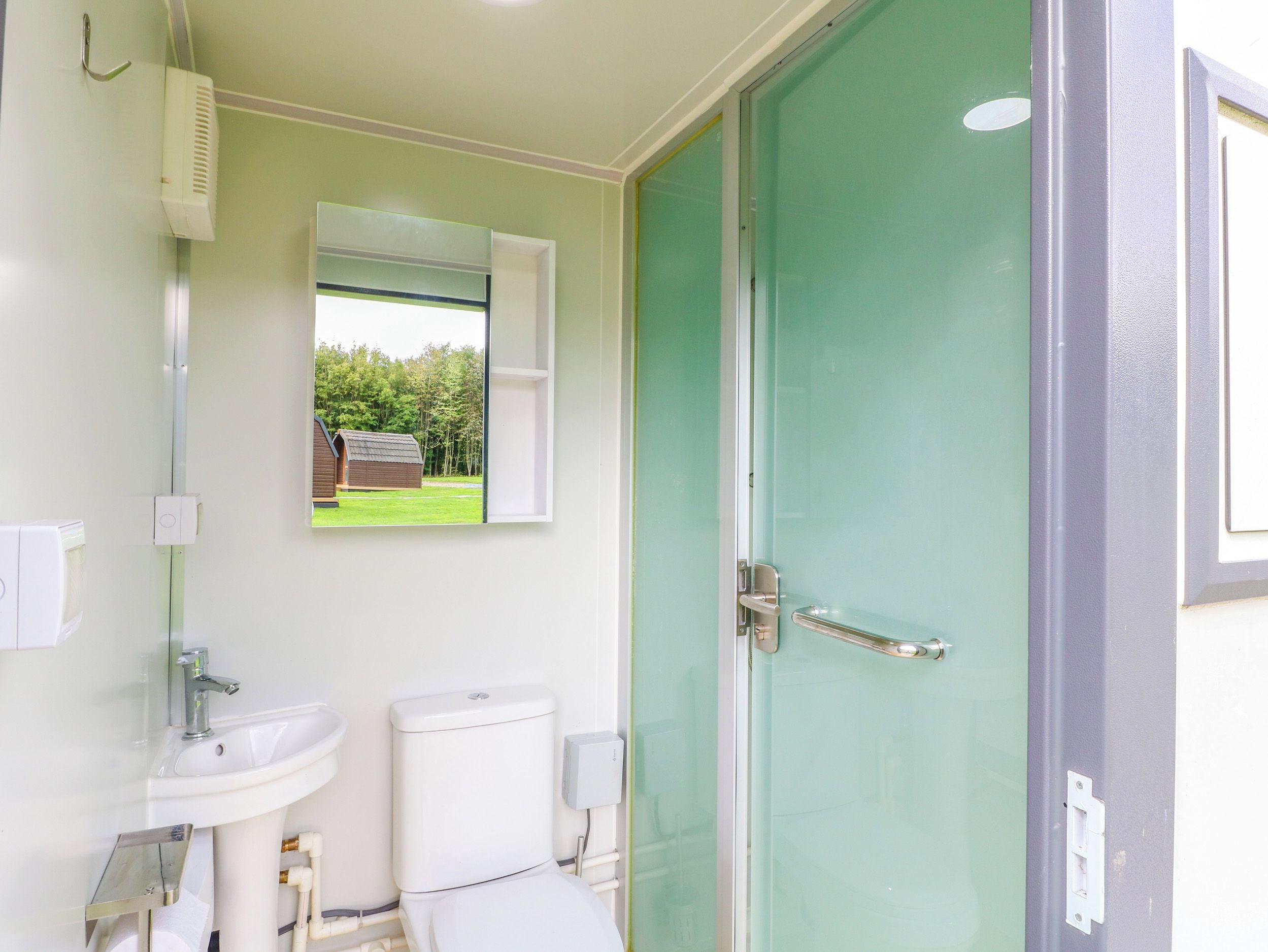 Een badkamer met toilet, wastafel en douche.