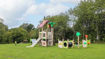 A playground with a slide, climbing structures, and educational play panels.