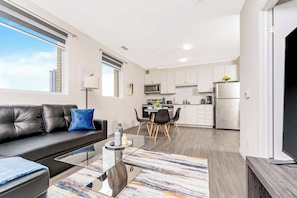 A modern apartment with a living area, kitchen, and dining space.