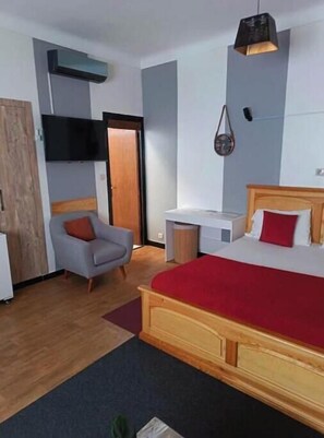 A bedroom with a bed, a chair, a desk, and a TV. - Le Secret | Elegance & Comfort in the Heart of Rabat (Rabat)