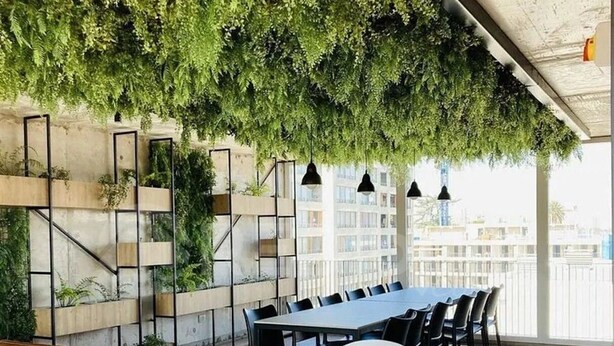 A conference room with a long table, chairs, and a green wall with plants. - Rbk Wifi Smart TV Cowork y Terraza verde (Santiago)