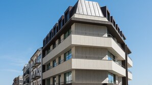 En byggnad med flera våningar och en unik, vinklad design, med balkonger och stora fönster.