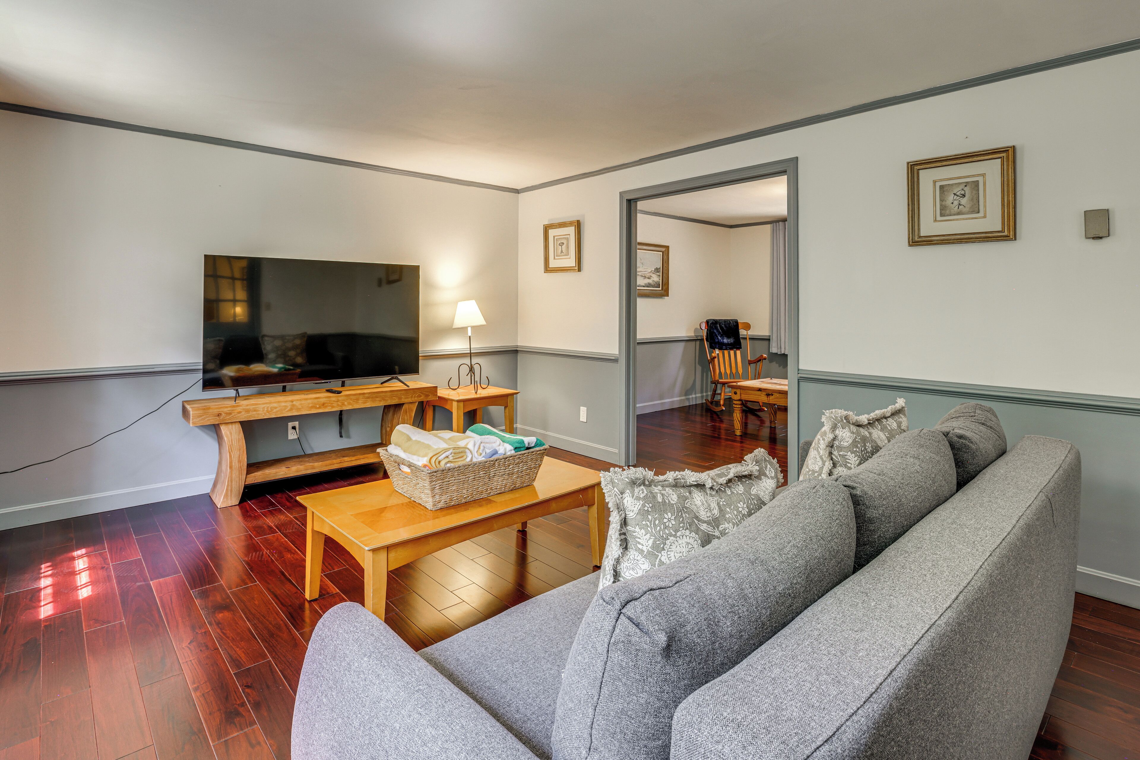 A living room with a sofa, a television, a wooden coffee table, and a lamp.