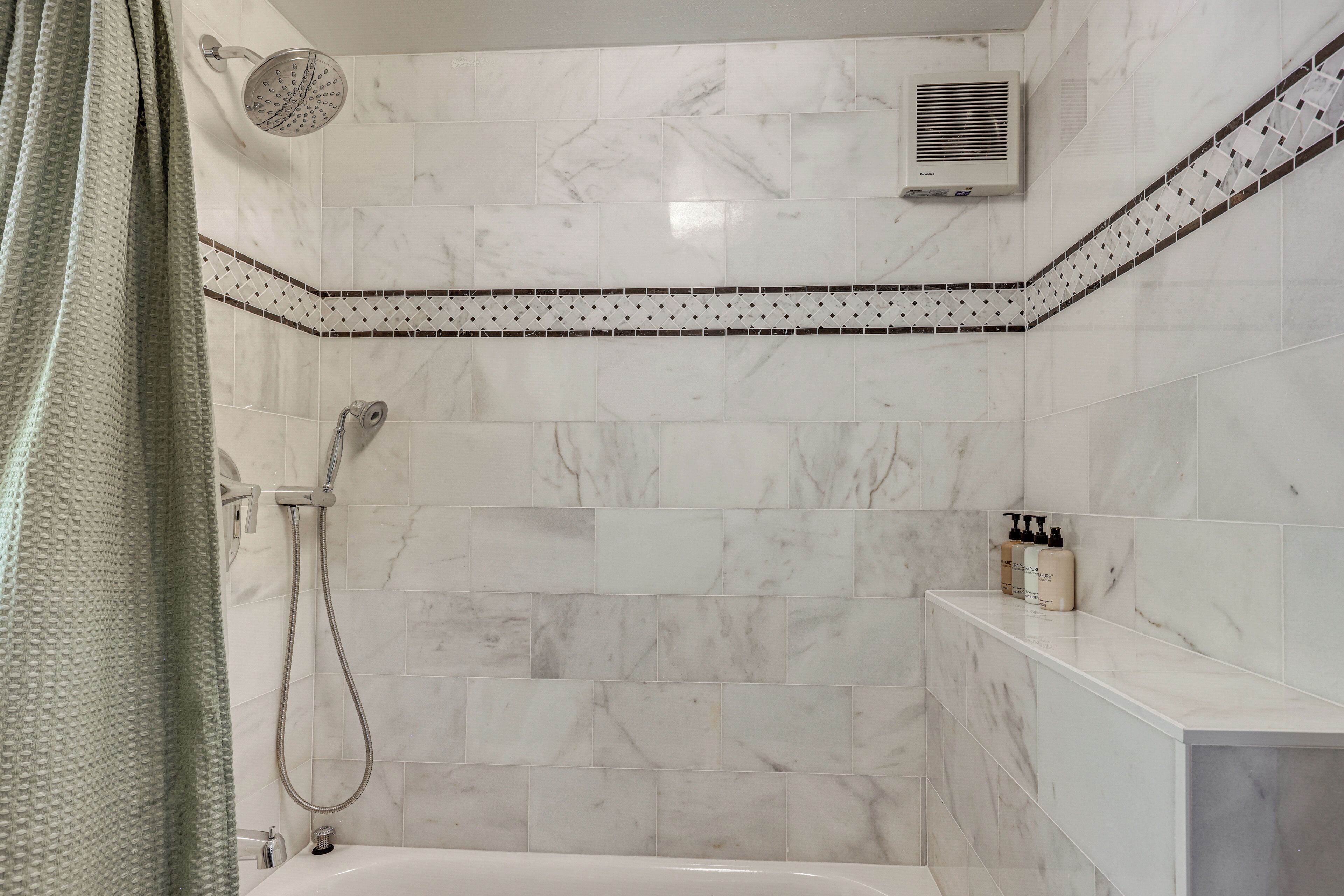 Une salle de bain équipée d’une douche, d’une baignoire et d’un porte-serviettes.