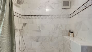 Une salle de bain équipée d’une douche, d’une baignoire et d’un porte-serviettes.