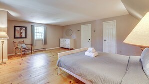 A bedroom with a bed, a dresser, a chair, a window, and a lamp. - Classic Cape House 5M to Nauset Beach (Orleans)