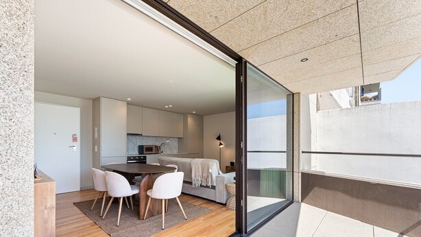 Un intérieur moderne comprenant un coin repas, une cuisine et un balcon avec vue.