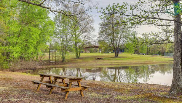 A picnic table by a pond with trees and a gazebo in the background. - Studio w/ Greers Ferry Lake Access & Resort Perks! (Clinton)