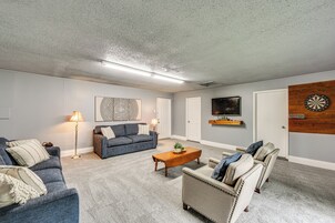 Una sala de estar con sofá, sillón, mesa de centro y un dardo.
