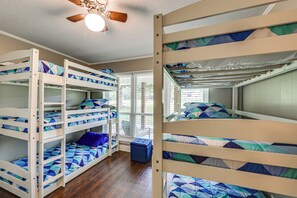 A bunk bed room with a ceiling fan, wooden flooring, and a window with blinds. - Cedar Creek Lake 'amarianna Cove' Paradise! (Mabank)