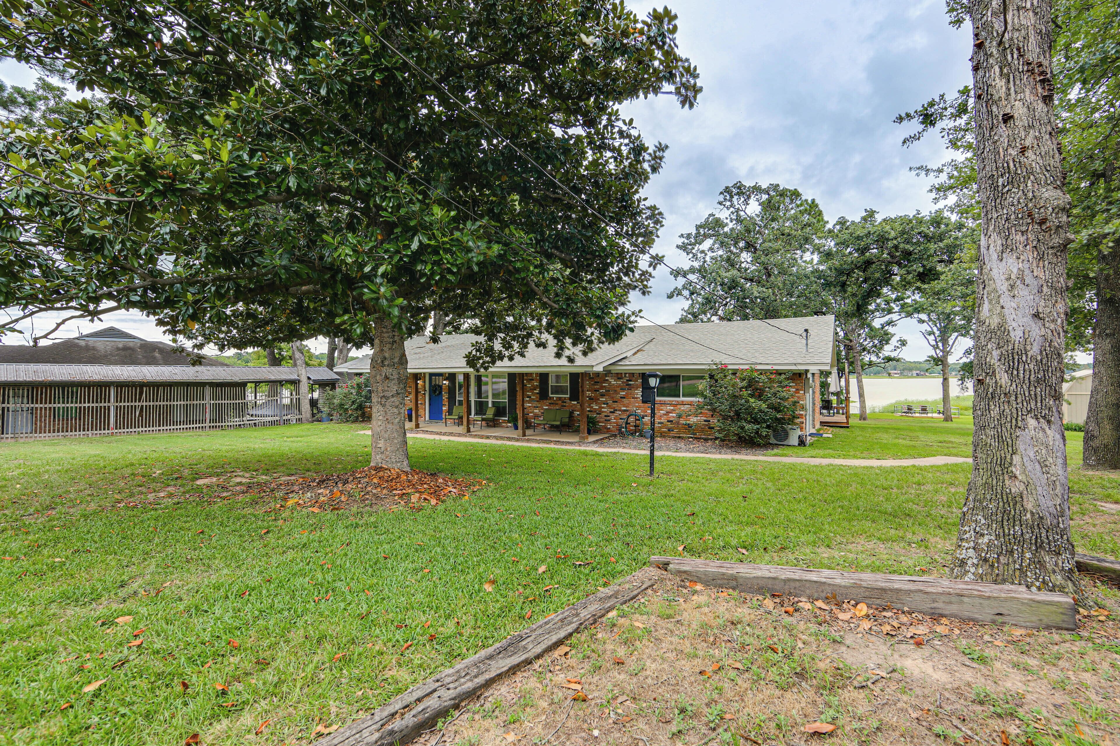A building with a brick facade, a lawn, and a tree.
