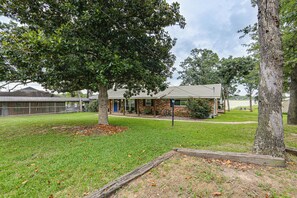 A building with a brick facade, a lawn, and a tree. - Cedar Creek Lake 'amarianna Cove' Paradise! (Mabank)