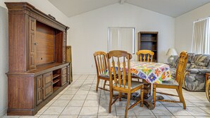A dining area with a wooden table, chairs, a cabinet, and a sofa. - Great for Couples & Duos: Suite Outside El Paso (El Paso)