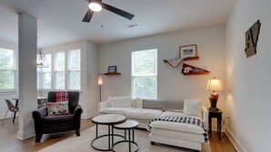 A living room with a ceiling fan, a fireplace, a sofa, a chair, and a coffee table. - Near Centennial Park! Fayetteville Extended Stay (Fayetteville)