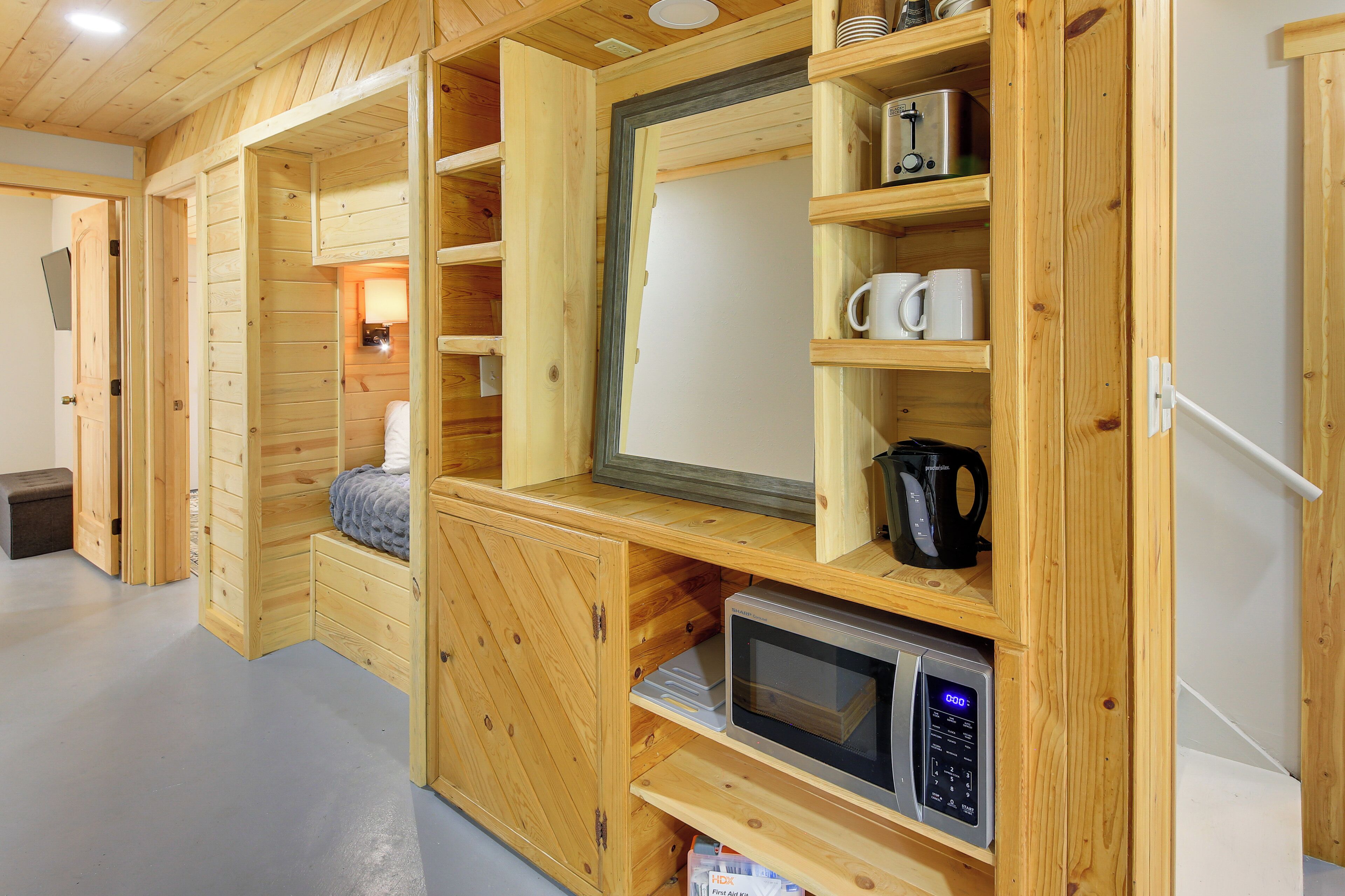 Un intérieur en bois avec des étagères intégrées, un four à micro-ondes et une machine à café.