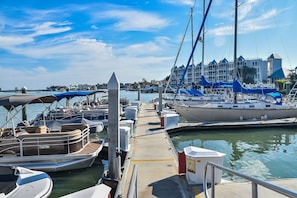 A marina with boats docked, a pier, and a building with a blue roof in the background. - Tropical Paradise Marco Island Retreat- Pool, Hot tub, Dolphin Tiki Bar (Marco Island)