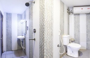 Ein Badezimmer mit Dusche, Toilette und Waschbecken, ausgestattet mit Mosaikfliesen an den Wänden und einem weißen Boden.