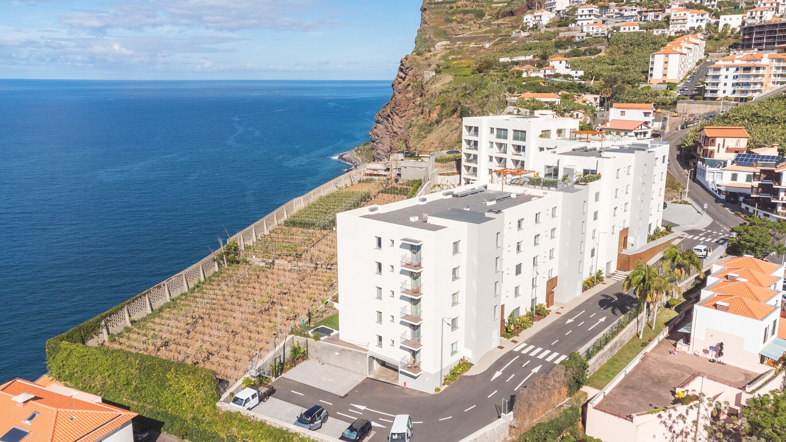Una zona residencial costera con edificios modernos, una carretera y vistas al mar.