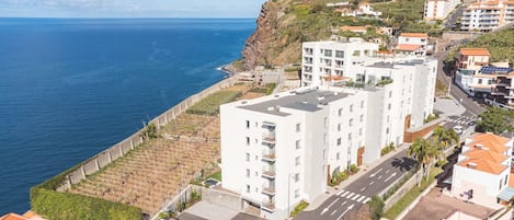 Una zona residencial costera con edificios modernos, una carretera y vistas al mar.