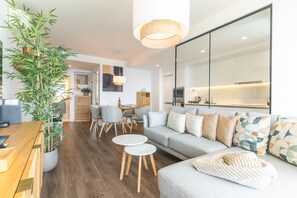 A modern living room with a sofa, coffee table, and dining area. - Azure Atlantic Horizon by Atlantic Holiday (Câmara de Lobos)