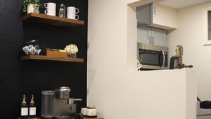 Cozinha com cafeteira, garrafas e micro-ondas.