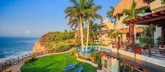 An exclusive beach house, perched on a cliff with panoramic ocean views.